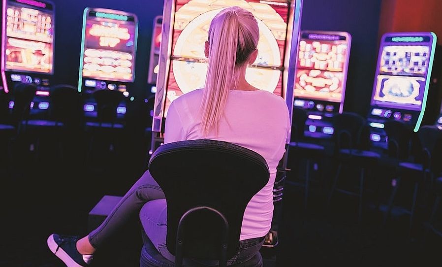 Blonde playing at a slot machine